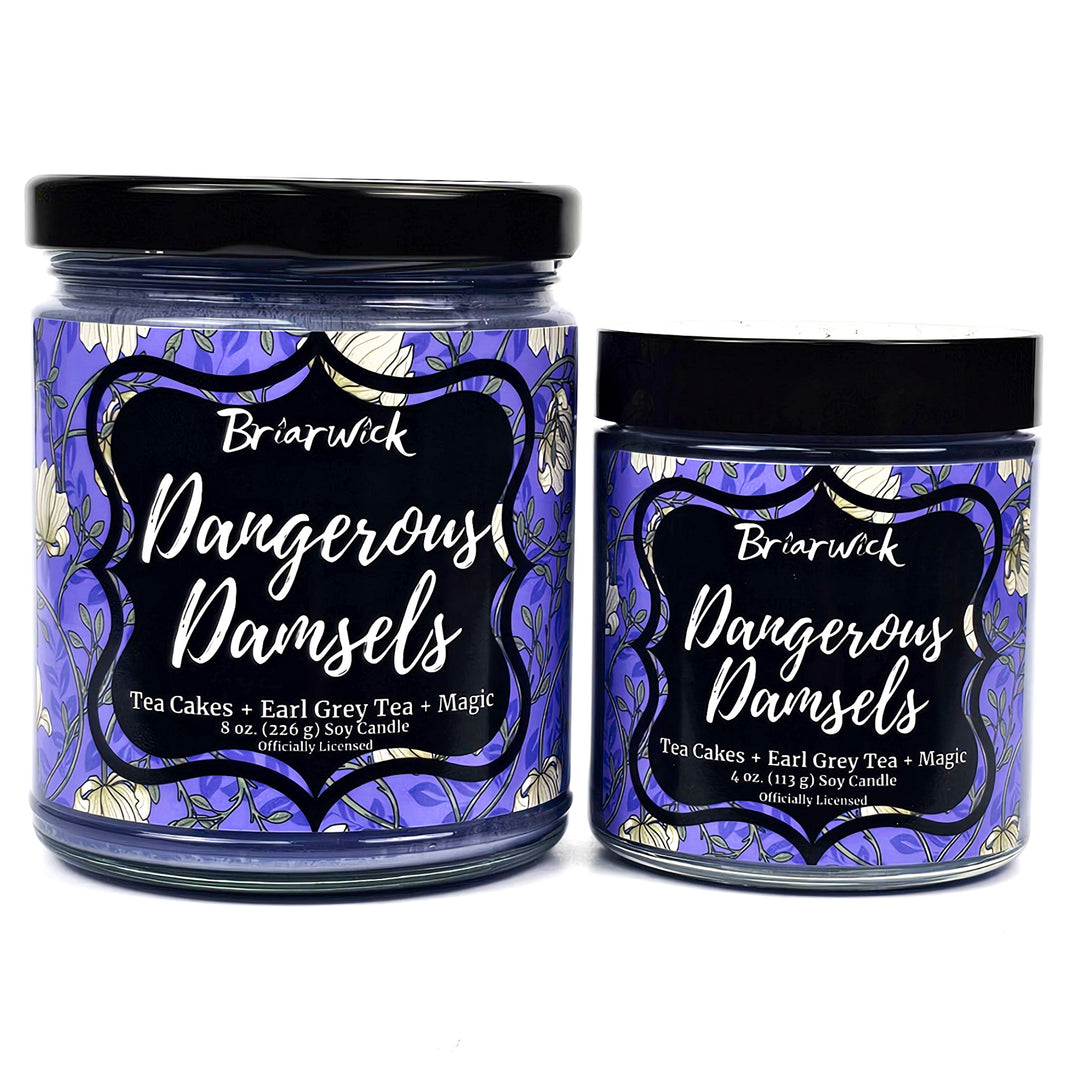 two purple candles with floral labels called Dangerous Damsels on a white background