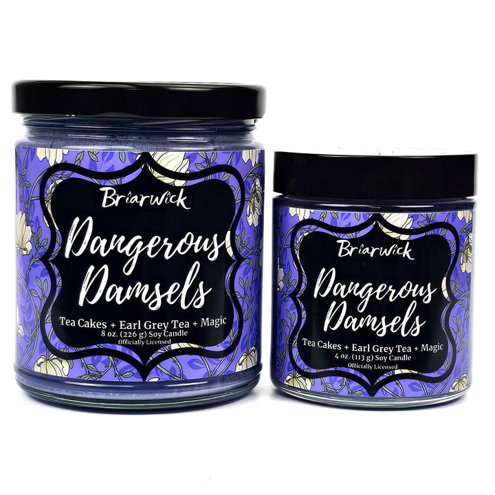 two purple candles with floral labels called Dangerous Damsels on a white background