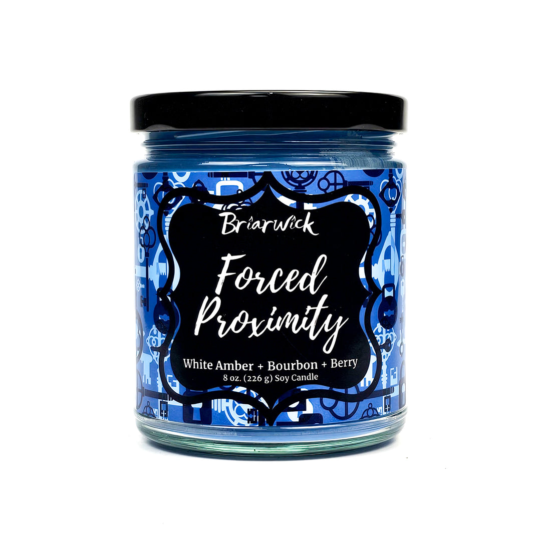 Forced Proximity 8oz steel blue candle with blue lock & key design on a white background