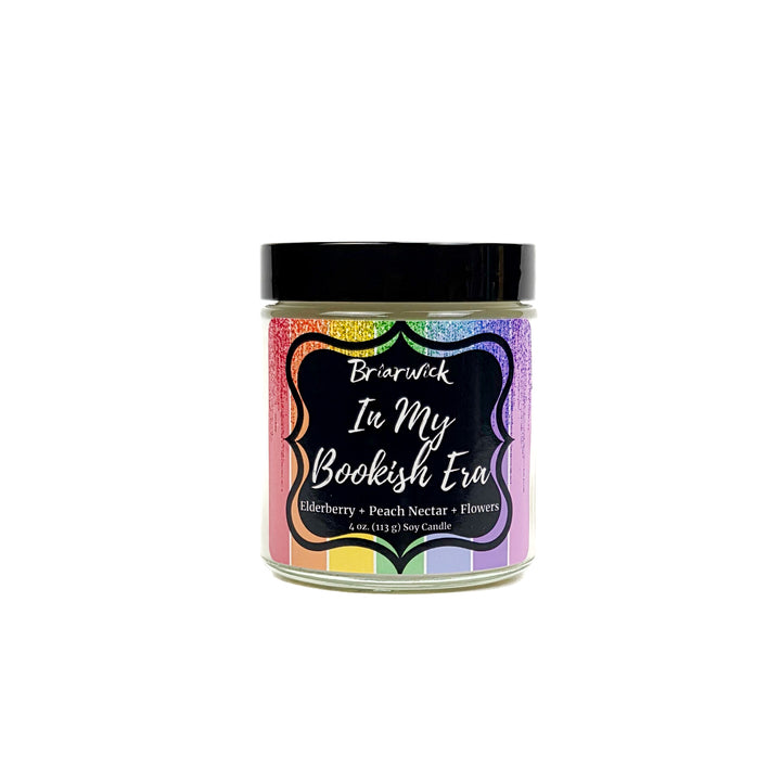 In My Bookish Era 4oz white candle with sparkly rainbow design on a white background