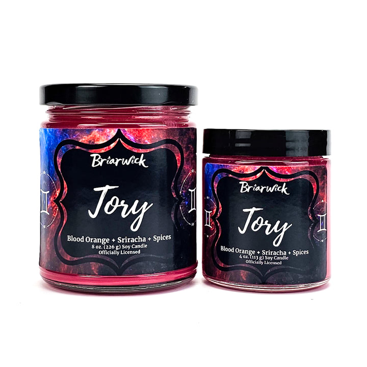 Tory 8oz & 4oz cherry red candles with blue galaxy gemini designs on a white background