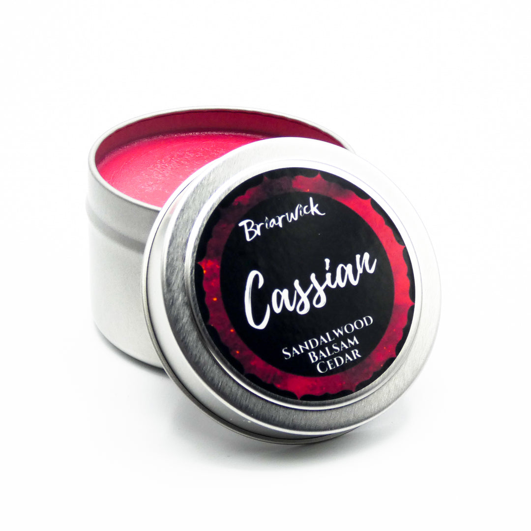 a tin of pink lip polish sitting on top of a white surface
