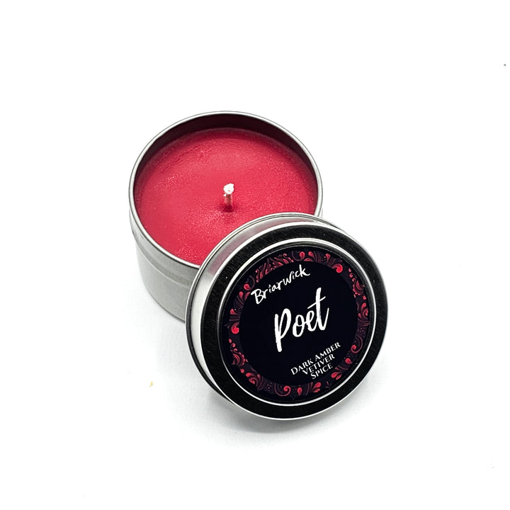 a small tin with a pink candle inside of it