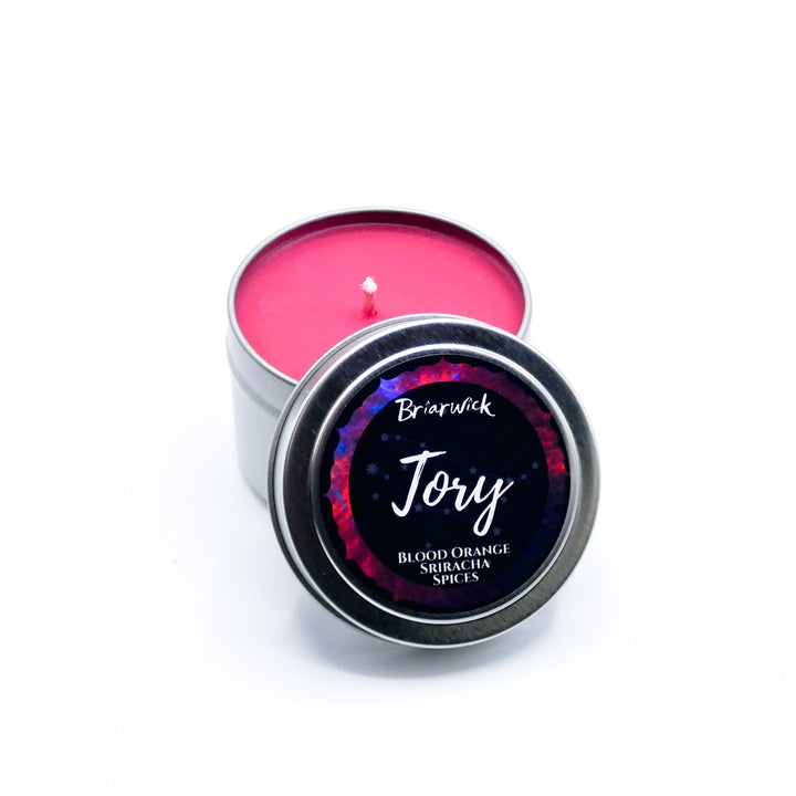 a tin of pink colored wax sitting on a white surface