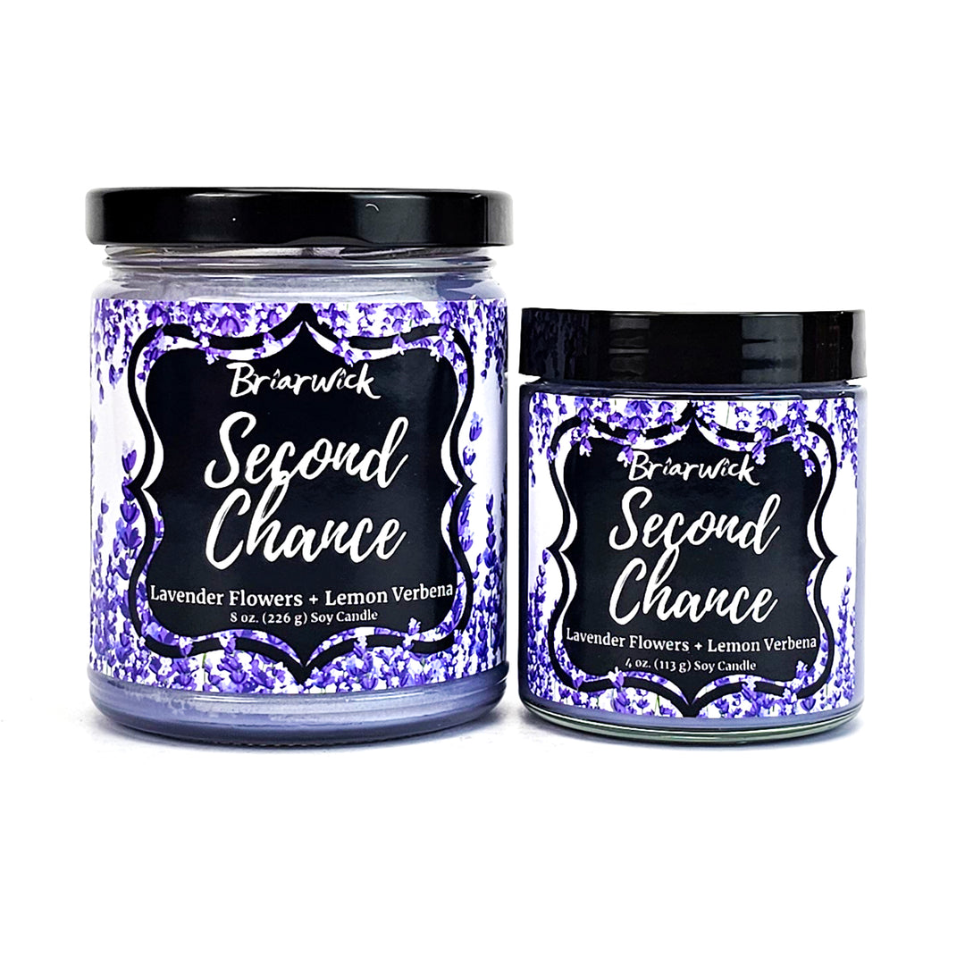 two jars of scented candles sitting next to each other