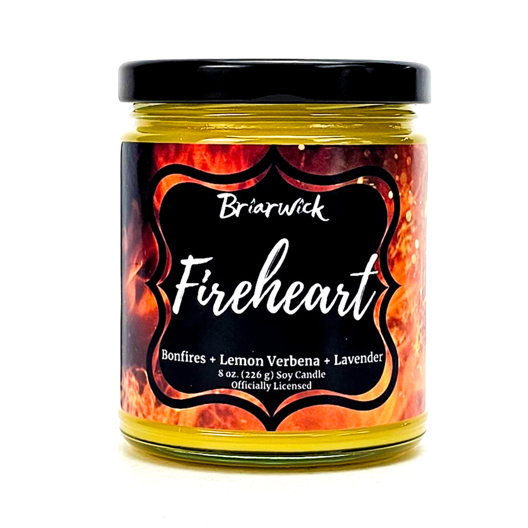 Fireheart 8oz canary yellow candle with orange flame design on a white background