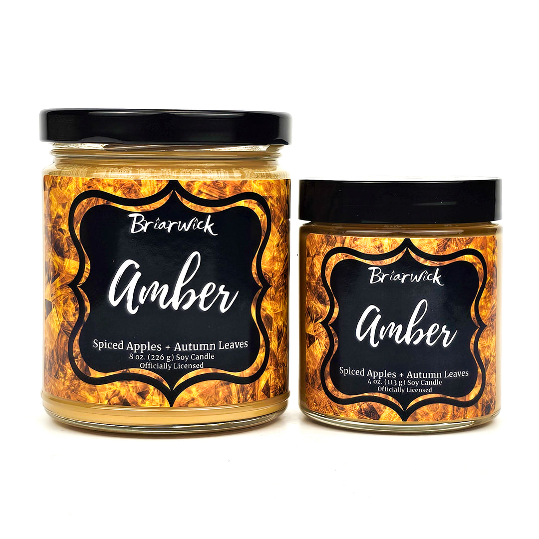 two jars of amber with black labels on them