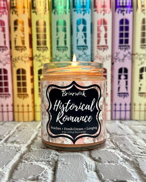 Candle labeled 'Historical Romance' with books with spines featuring colorful houses in the background