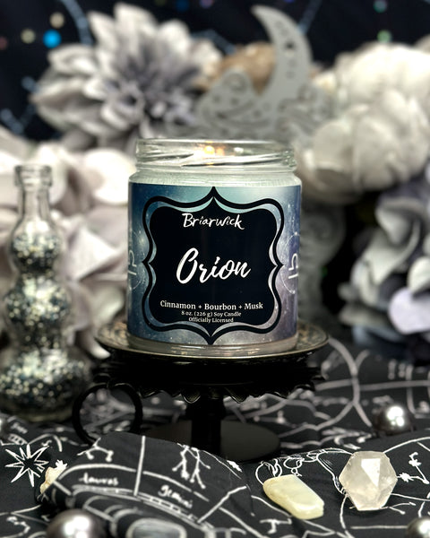 Candle labeled 'Orion' by Brierwick on a mystical background with crystals and stars.