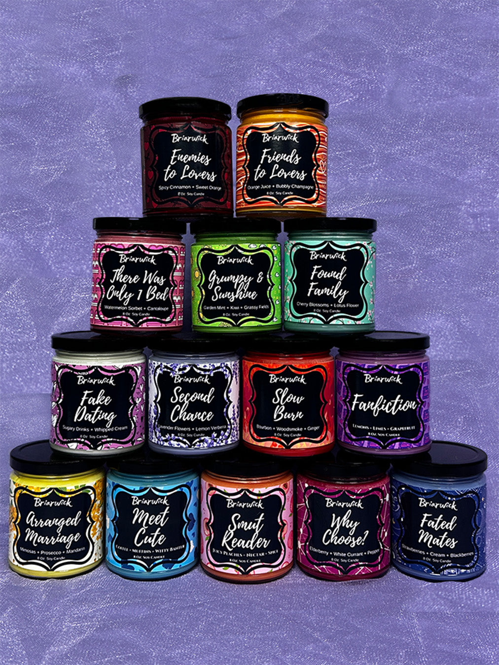 Multiple candles stack on top of each other with the titles of the bookish troops they represent
