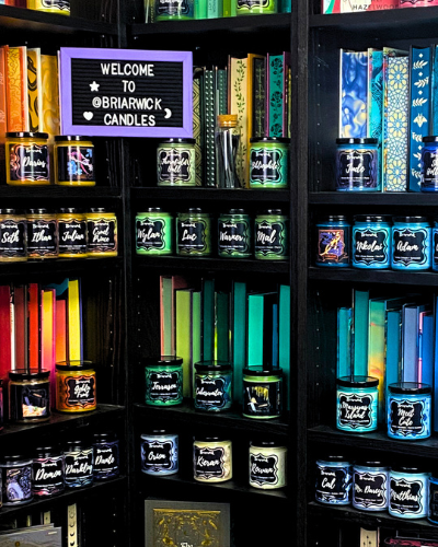 Display of colorful briarwick candles on a bookshelf