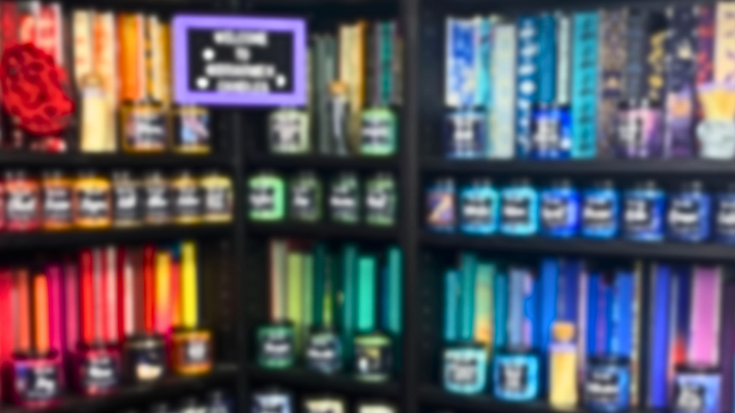 Blurry image of a bookshelf with books of various colors.
