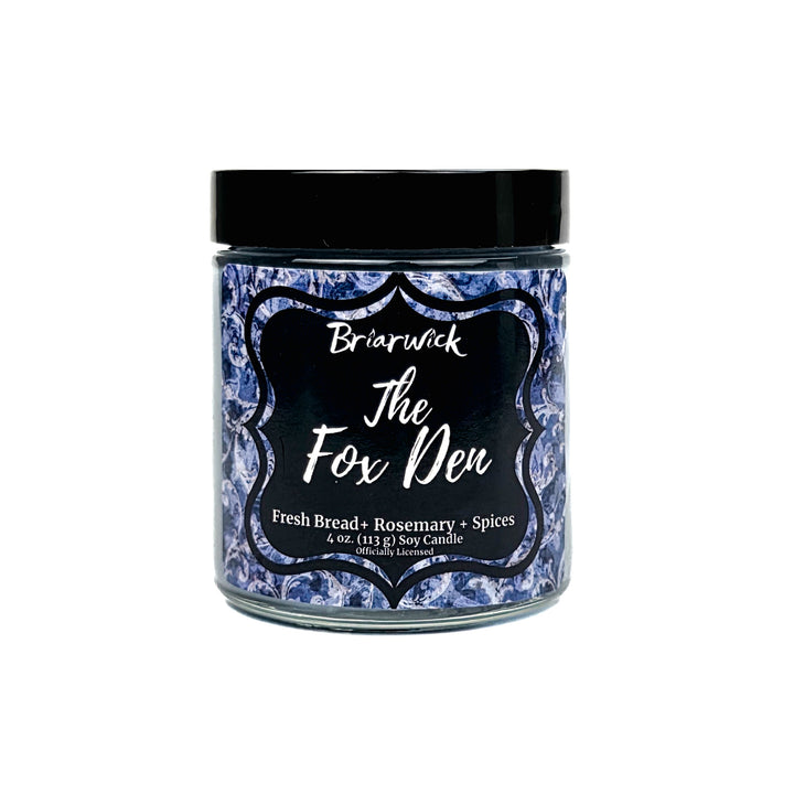 A jar candle from Briarwick The Fox Den with a black lid and a blue-and-white patterned label, shown on a plain white background.