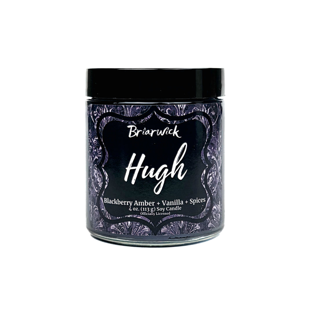 A jar candle labeled 'Briarwick Hugh' with a black lid and a dark purple label featuring white script and decorative border, on a plain white background.