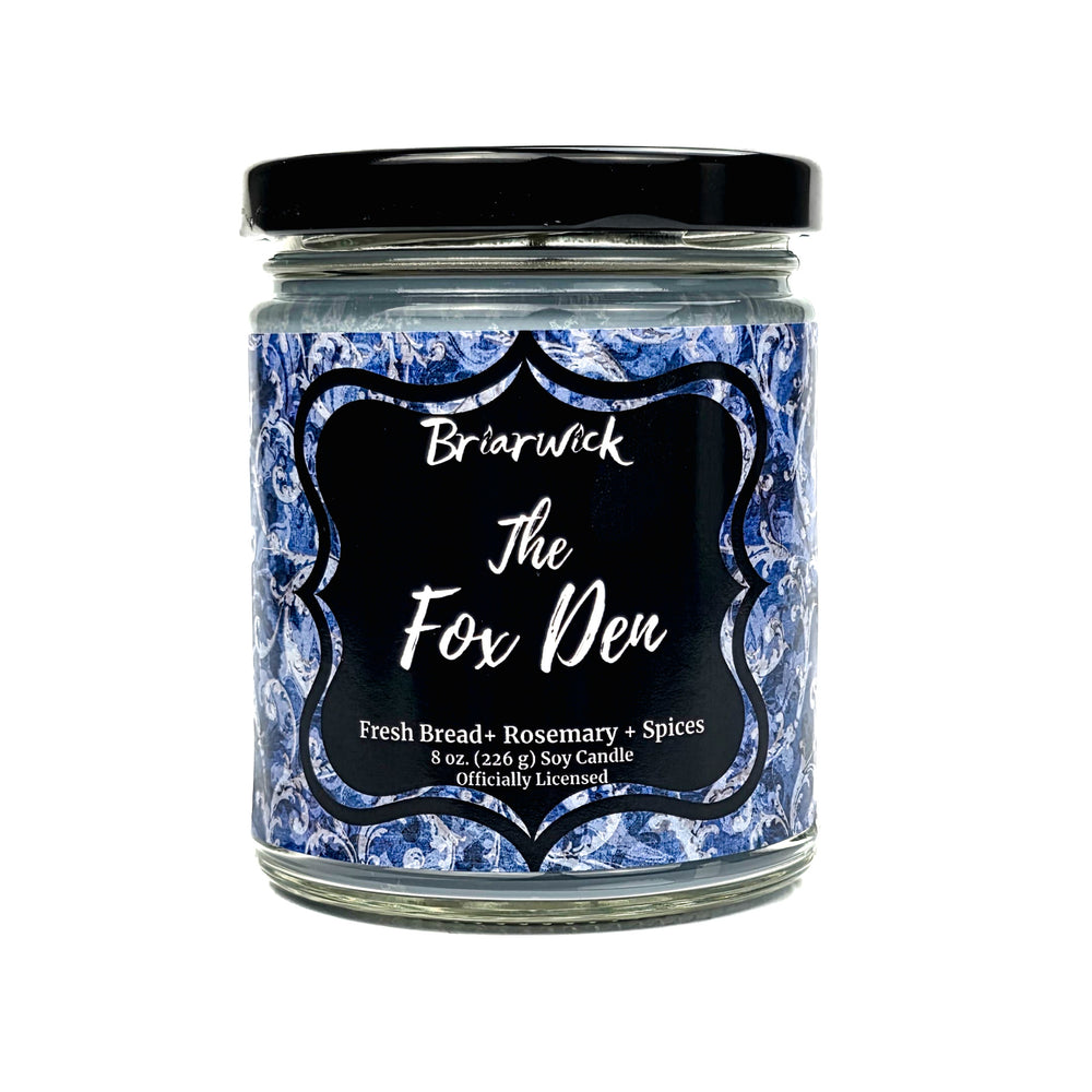 A jar candle with a black lid and a blue-and-white marbled label reading 'Briarwick The Fox Den' on a white background.