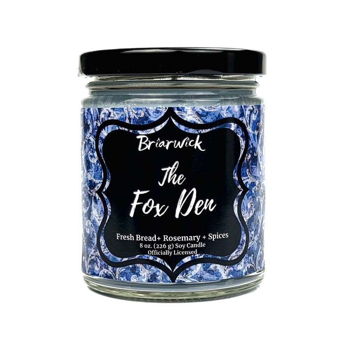 A jar candle with a black lid and a blue-and-white marbled label reading 'Briarwick The Fox Den' on a white background.