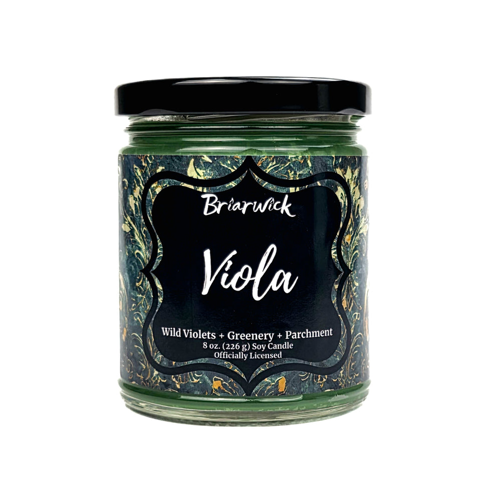 A Briarwick 'Viola' soy candle in a clear glass jar with a black lid and a black label featuring a dark green and gold marbled pattern.