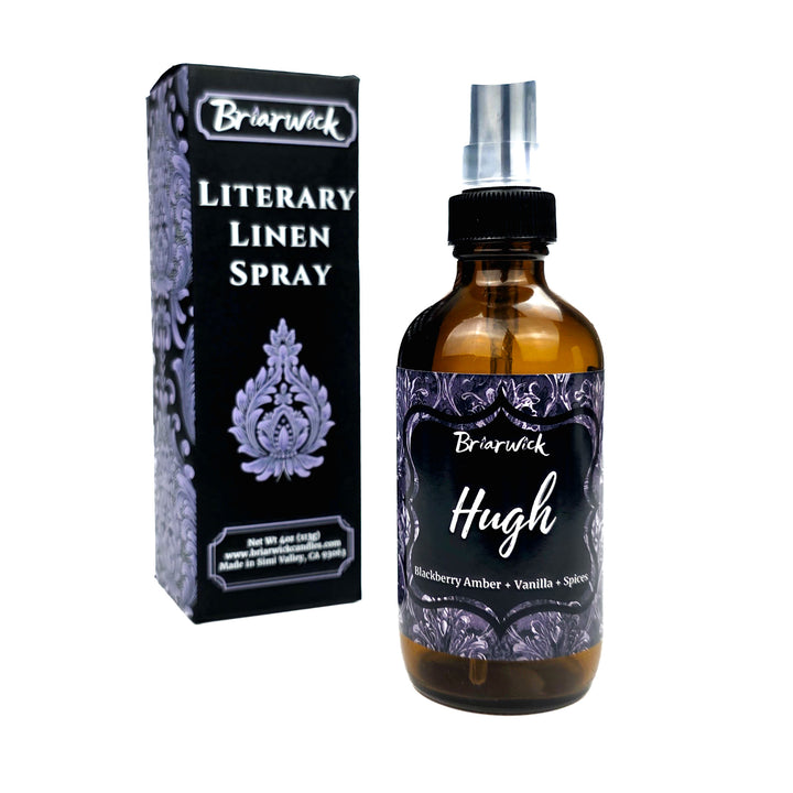 Briarwick Literary Linen Spray bottle with amber glass and a black spray top, shown next to its black retail box with lavender damask-style border and white text.