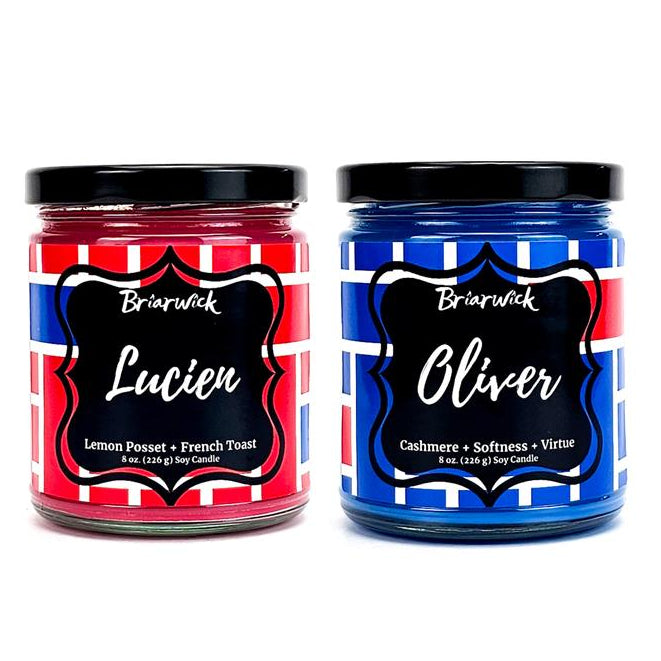 Two candles labeled 'Lucien' and 'Oliver' with red and blue striped labels on a white background.