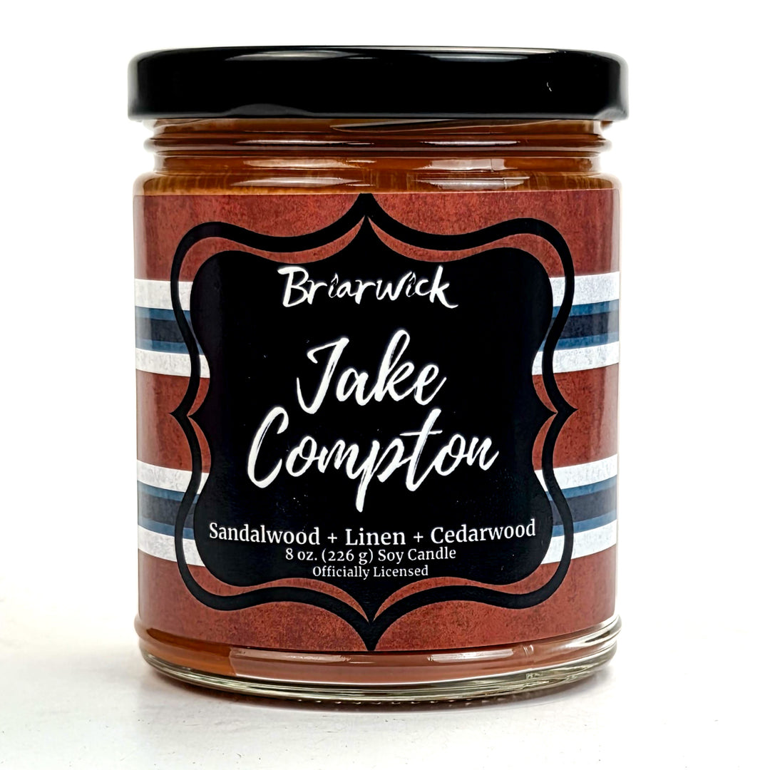 Jar of candle with 'Jake Compton' label on a white background