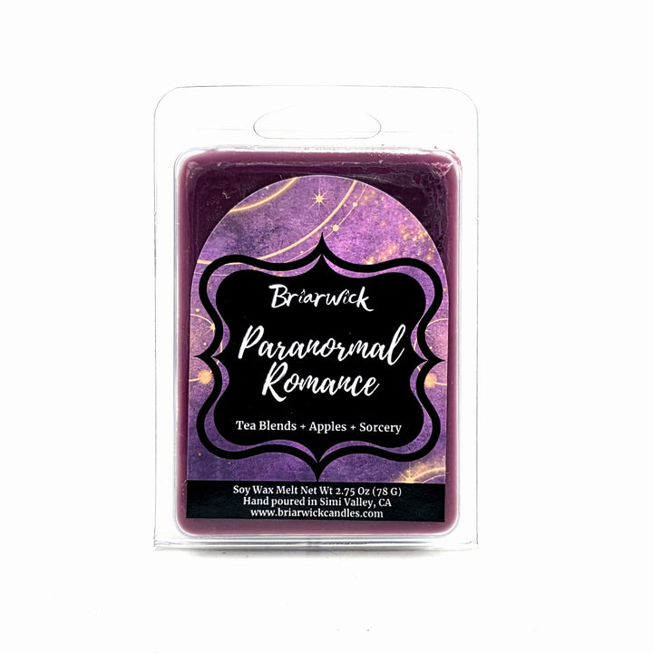 A packaged soy wax melt in a clear plastic clamshell package. The wax itself is a deep purple with a celestial pattern in the background, and the front label reads 'Briarwick Paranormal Romance' with 'Tea Blends + Apples + Sorcery'.