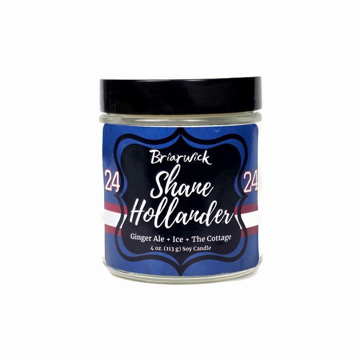 Jar of Shane Hollander candle with blue label on a white background