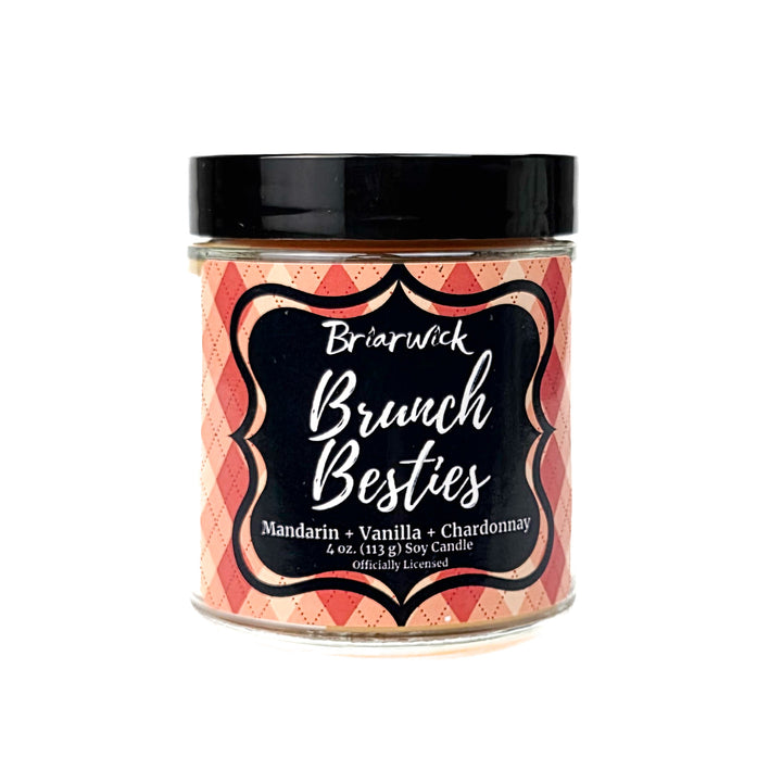 An orange Brunch Besties  4 oz candle by Briarwick on a white background