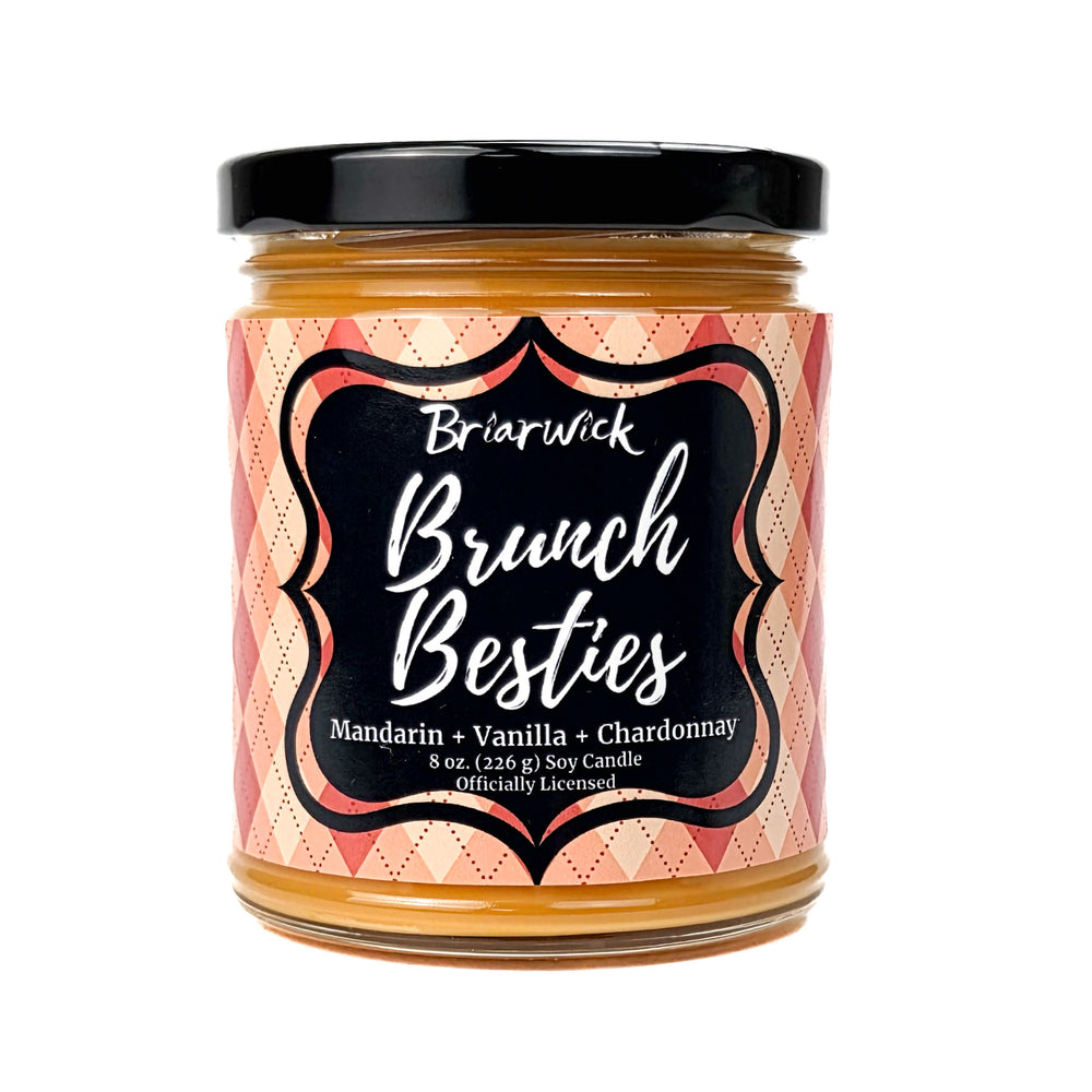 An orange Brunch Besties 8 oz candle jar by Briarwick on a white background