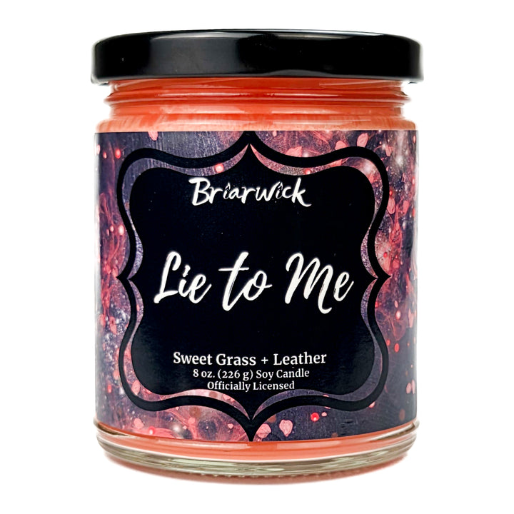 Briarwick 8oz soy candle in glass jar on a white background. Has black and red label with scent name Lie to Me