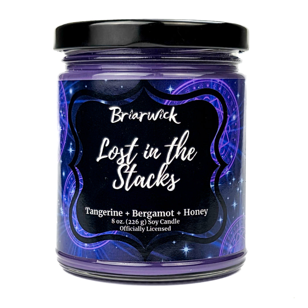 Briarwick 8oz soy candle in glass jar on white background. Indigo label has scent name Lost in the Stacks
