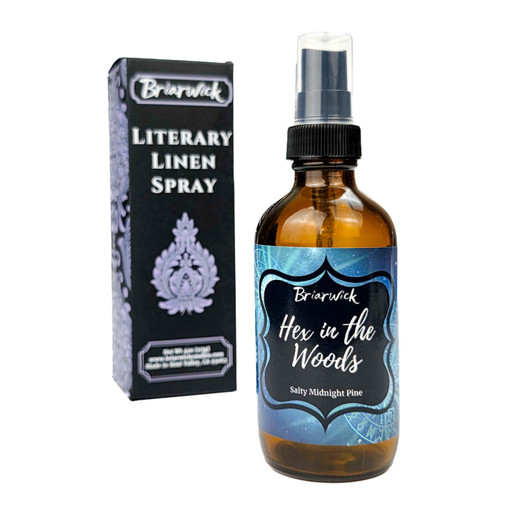 Briarwick Literary Linen Spray bottle and packaging on a white background. Amber bottle has teal label with scent name Hex in the Woods