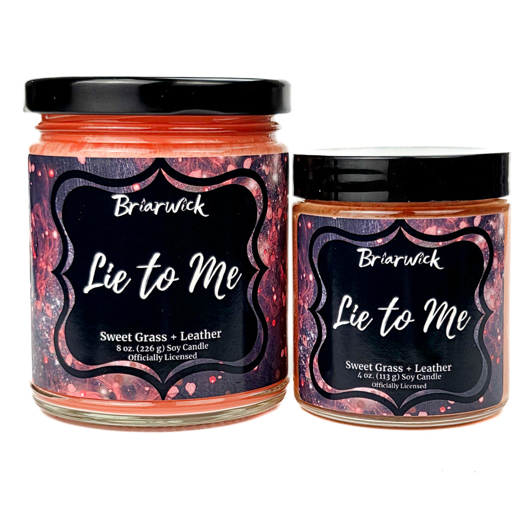 Two coral Briarwick 'Lie to Me' candles with black lids on a white background