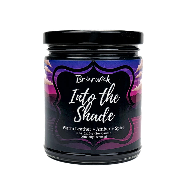 Candle jar labeled 'Into the Shade' by Briarwick with a black lid on a white background