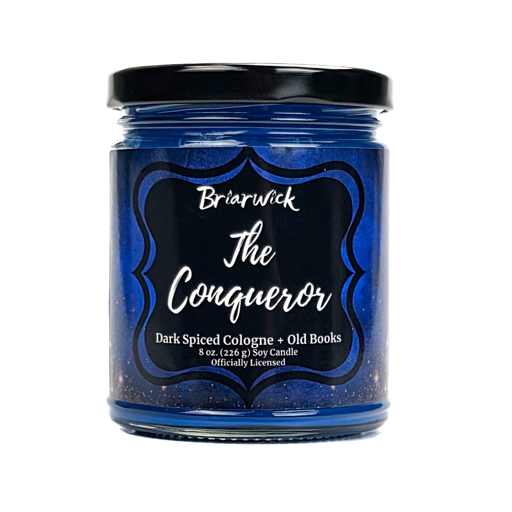Blue candle jar labeled 'The Conqueror' by Briarwick on a white background