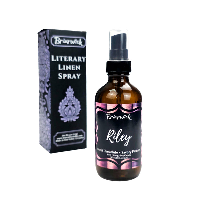 Briarwick Literary Linen Spray bottle and packaging on a white background. Amber glass bottle has scent name Riley on its pink label