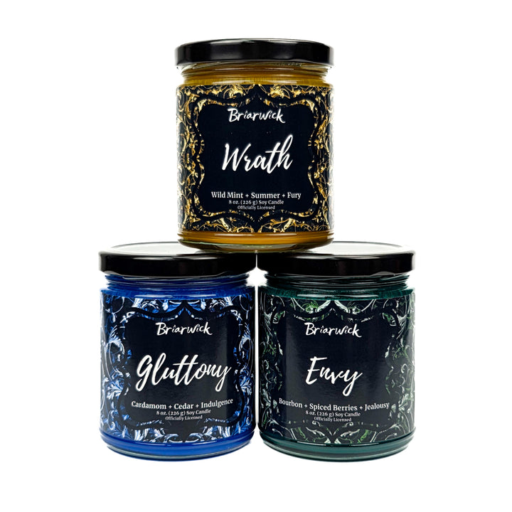 Three candles with labels 'Wrath', 'Gluttony', and 'Envy' on a white background