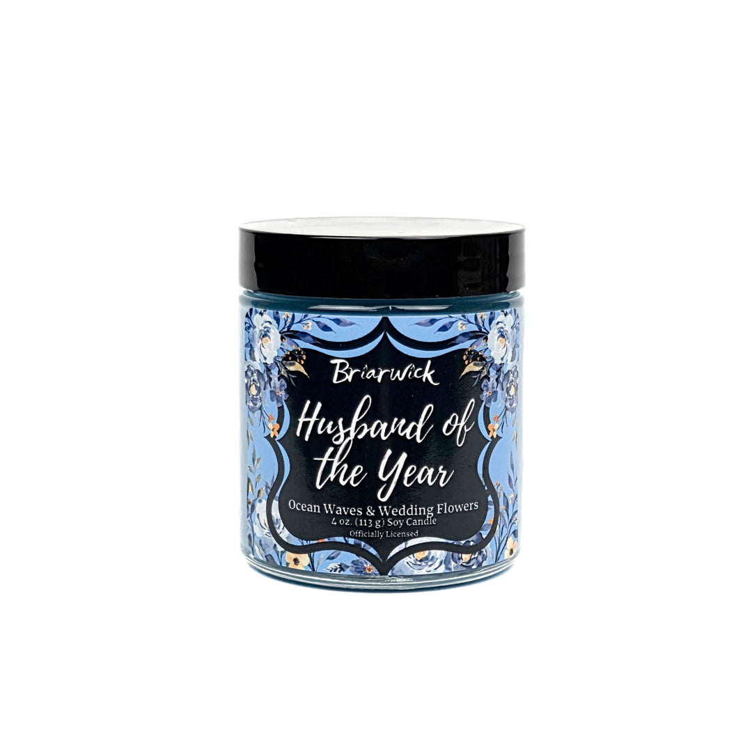 Blue Husband of the Year 4 oz jar candle decorated with blue and white flowers on a white background. 