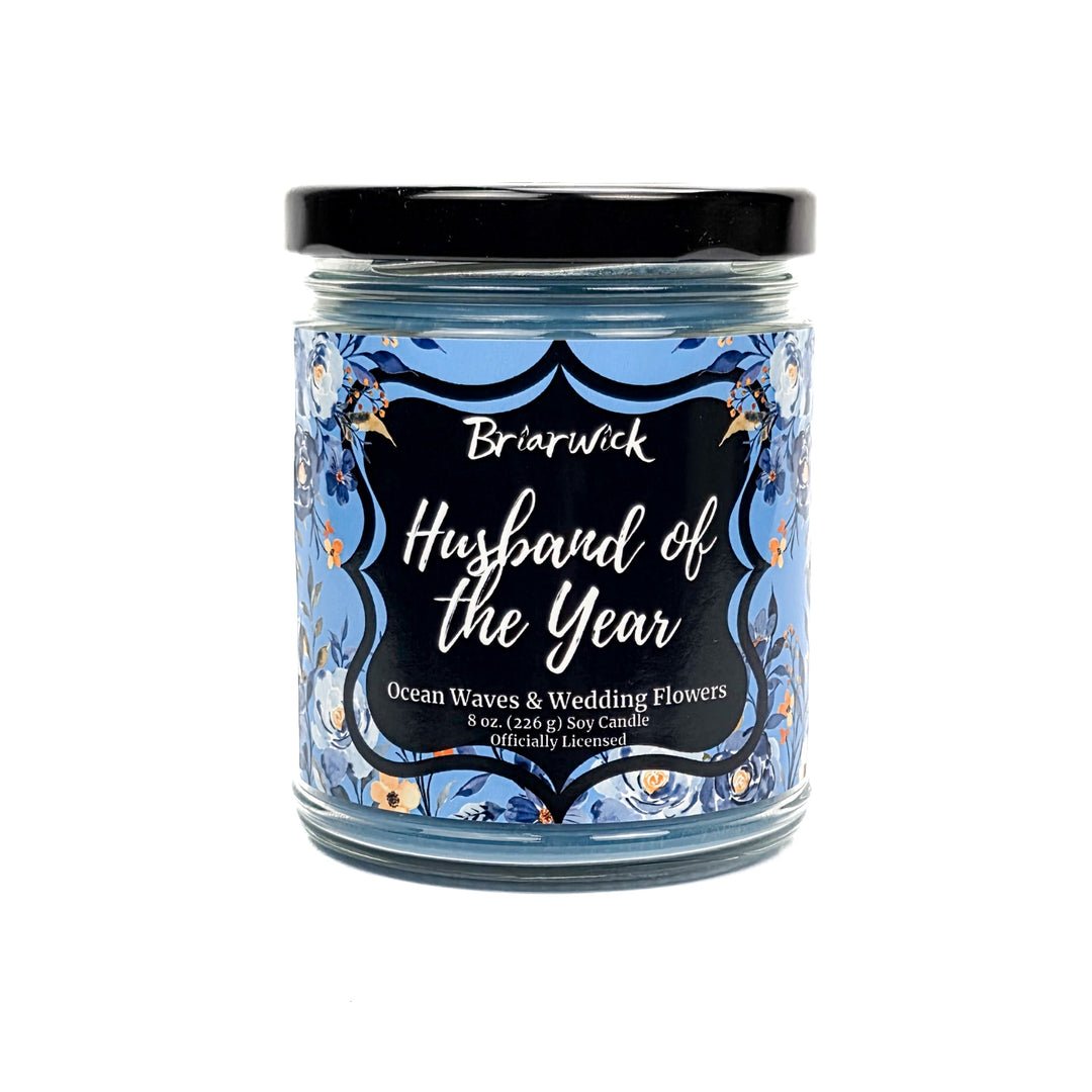 Blue Husband of the Year 8 oz jar candle decorated with blue and white flowers on a white background. 