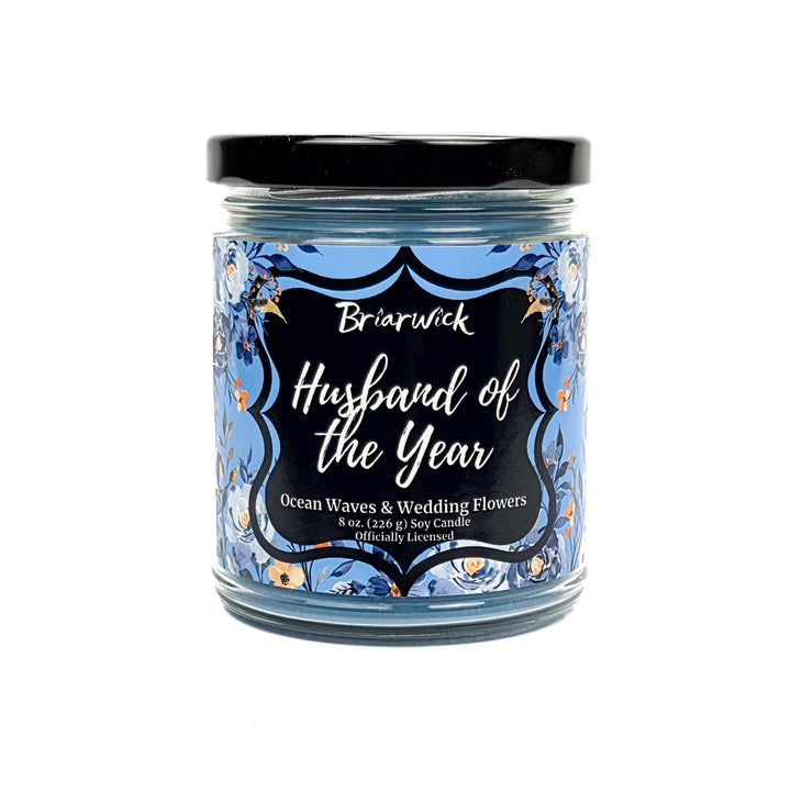 Blue Husband of the Year 8 oz jar candle decorated with blue and white flowers on a white background. 