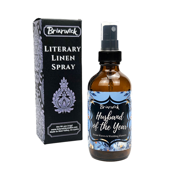 Blue Husband of the Year 4 oz linen spray bottle and box decorated with blue and white flowers on a white background. 