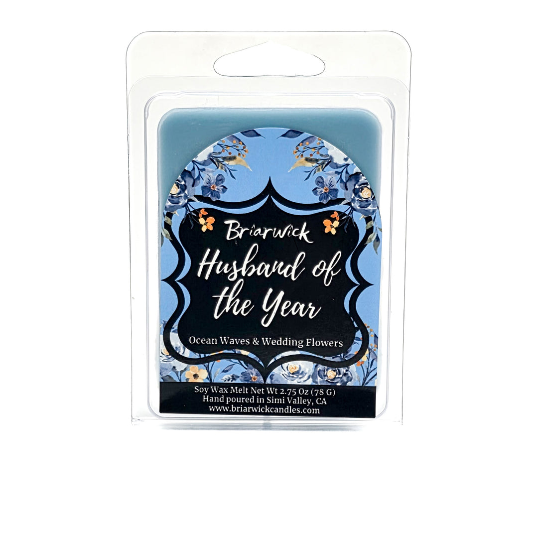 Blue Husband of the Year wax melt  decorated with blue and white flowers on a white background. 