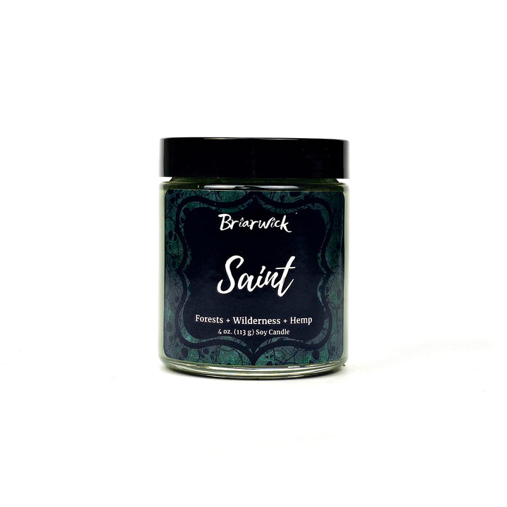 Saint 4oz olive candle with green skull design on a white background