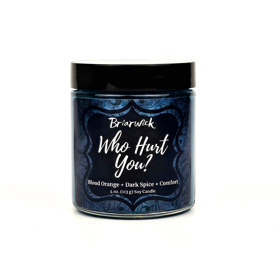 Who Hurt You? 4oz dark teal candle with blue ornamental design on a white background