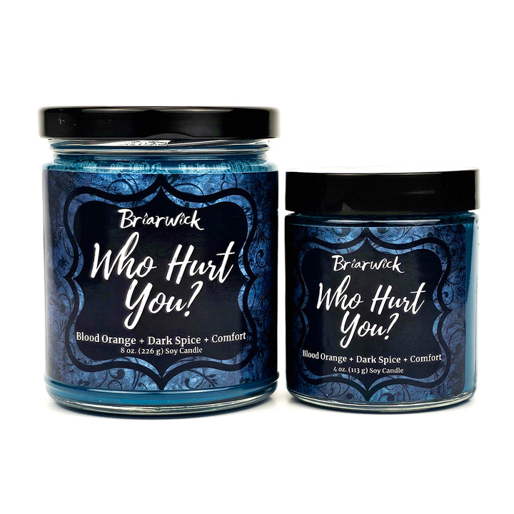 Who Hurt You? 8oz & 4ozx dark teal candles with blue ornamental designs on a white background