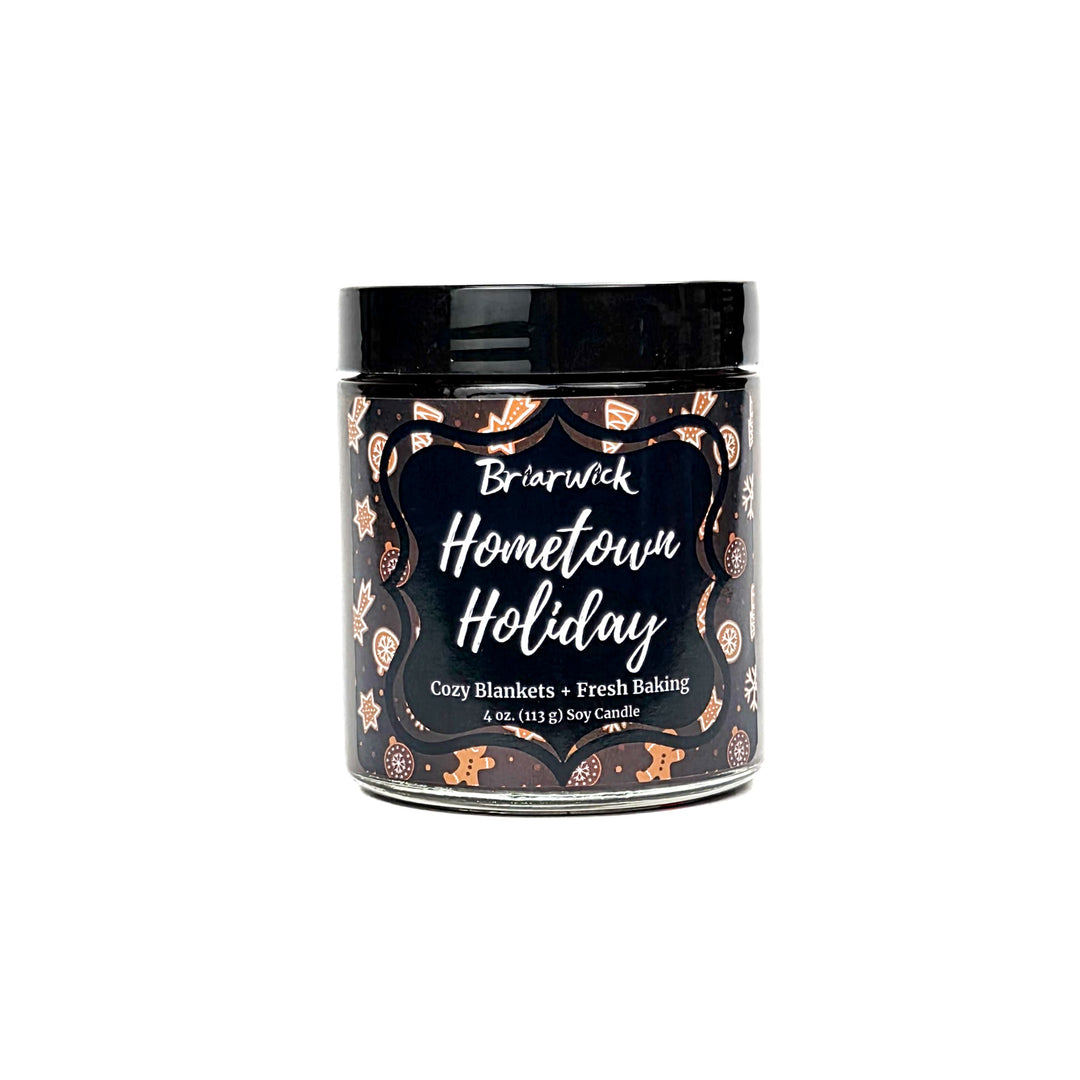 Hometown Holiday 4oz colored candle with brown and white decorated gingerbread  design on a white background