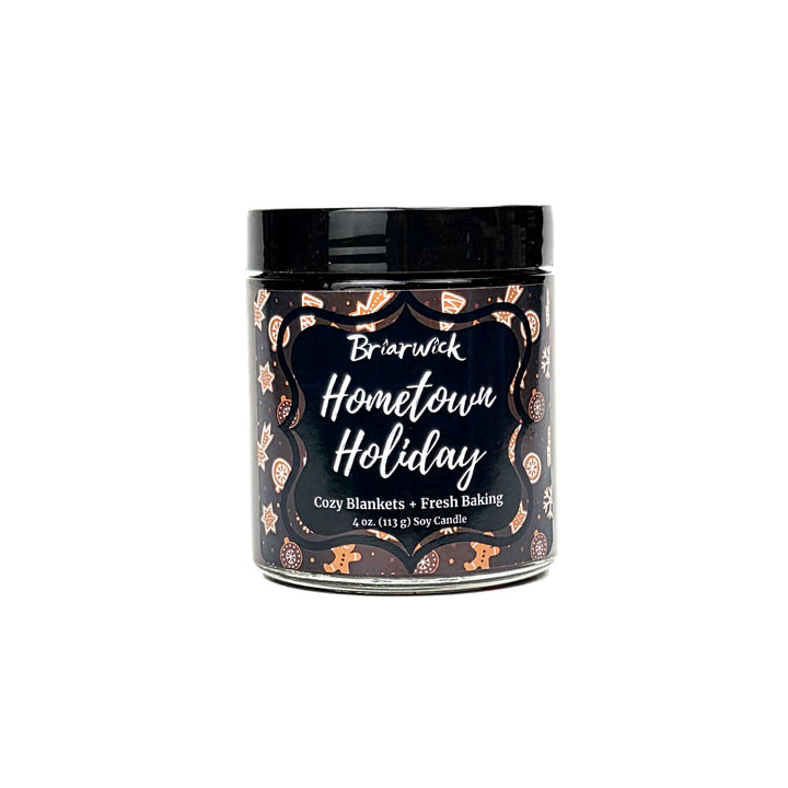 Hometown Holiday 4oz colored candle with brown and white decorated gingerbread  design on a white background