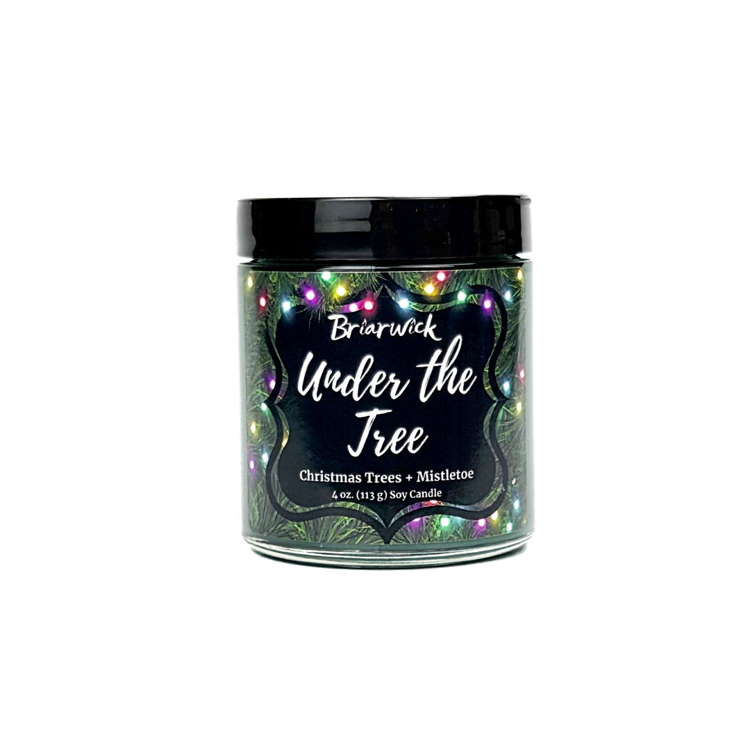Under the Tree 4oz colored candle with christmas tree and colorful lights design on a white background