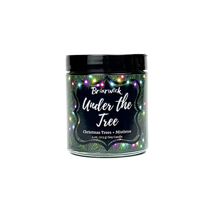 Under the Tree 4oz colored candle with christmas tree and colorful lights design on a white background