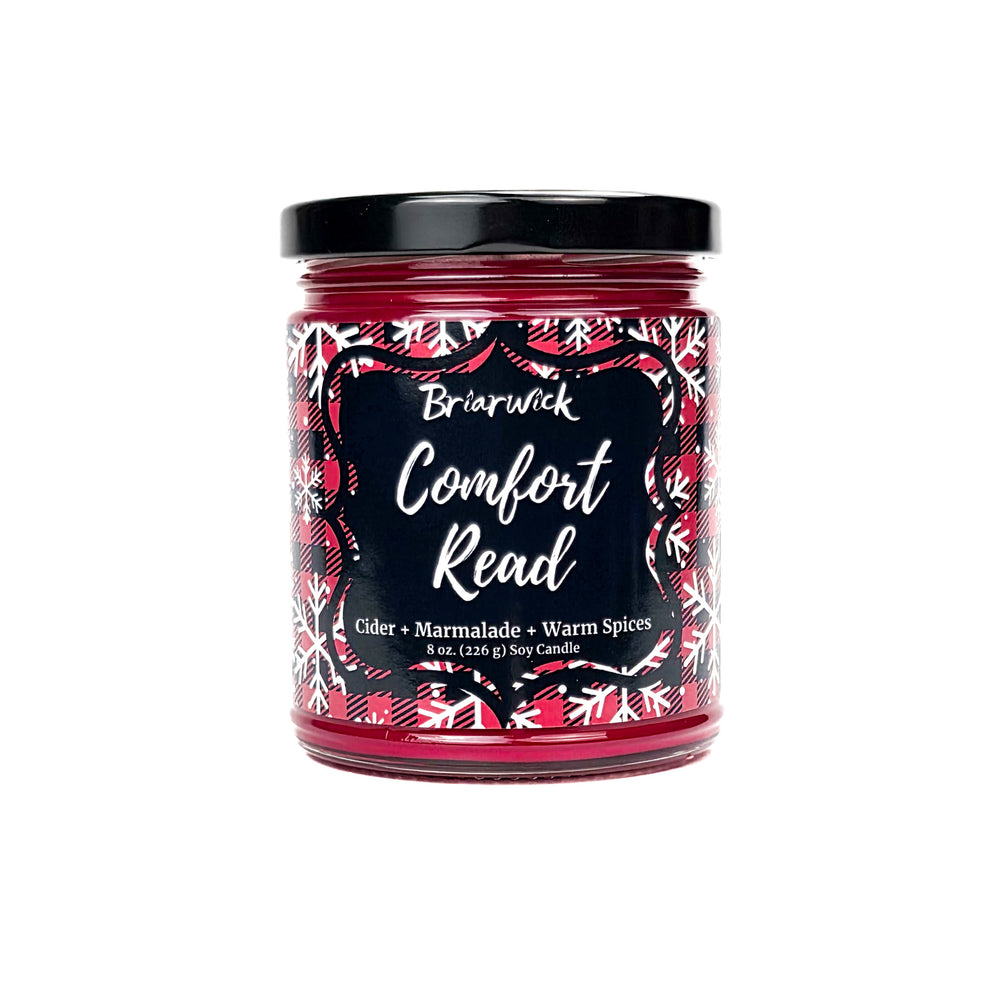 Comfort Read 8oz colored candle with red flannel and white snowflake design on a white background