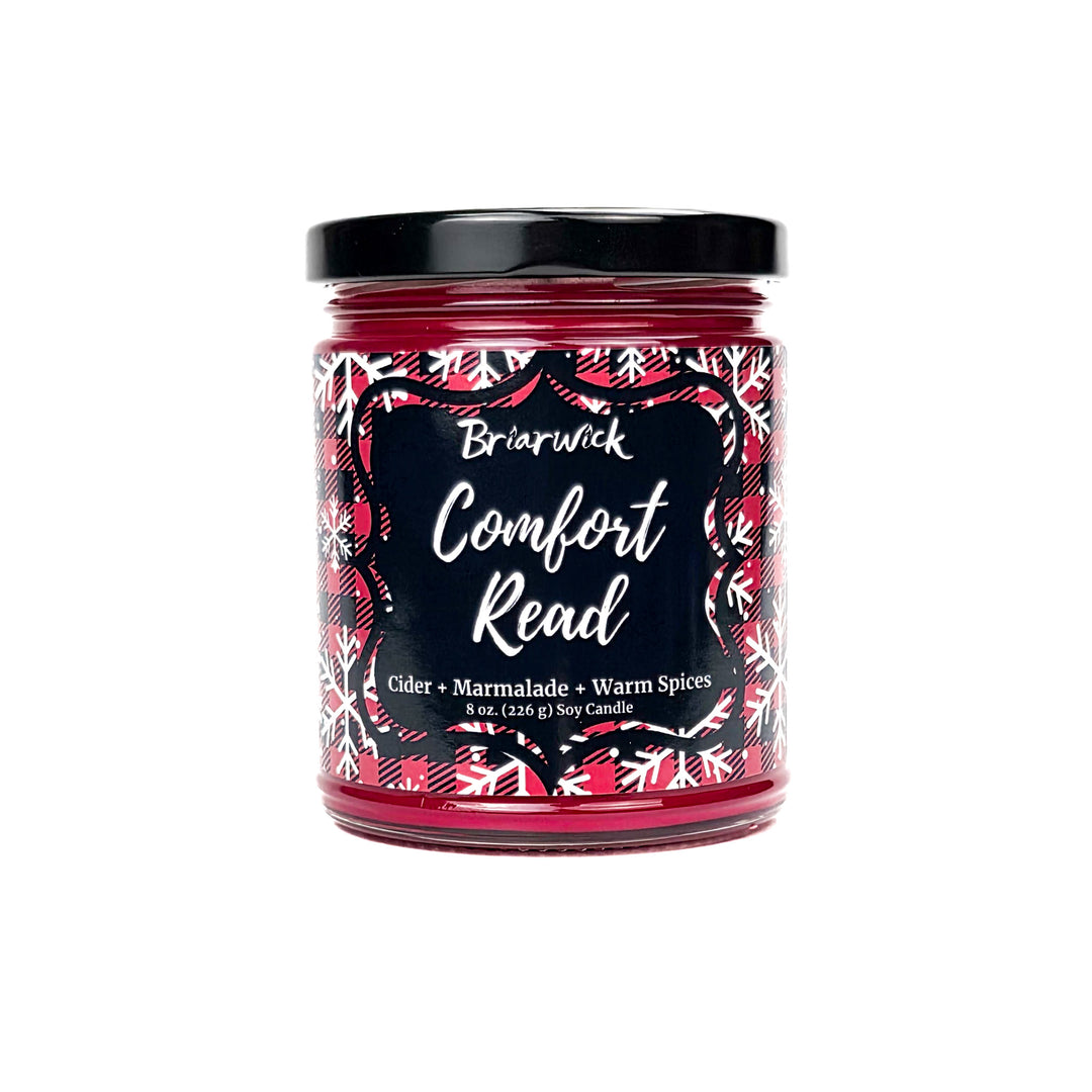Comfort Read 8oz colored candle with red flannel and white snowflake design on a white background